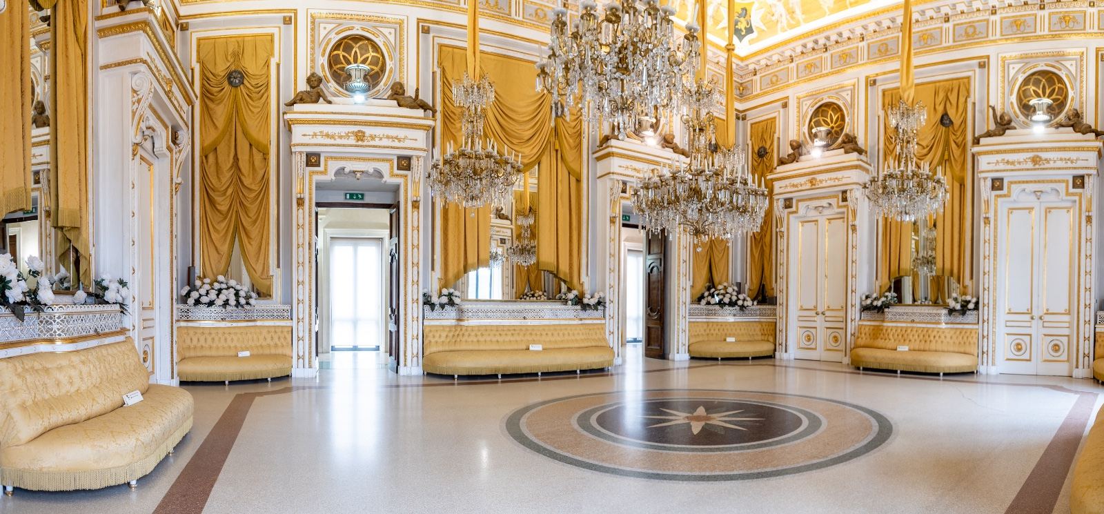 Il Salone degli Specchi del Castello Ducale di Corigliano, bianco e oro, con i lampadari di cristallo