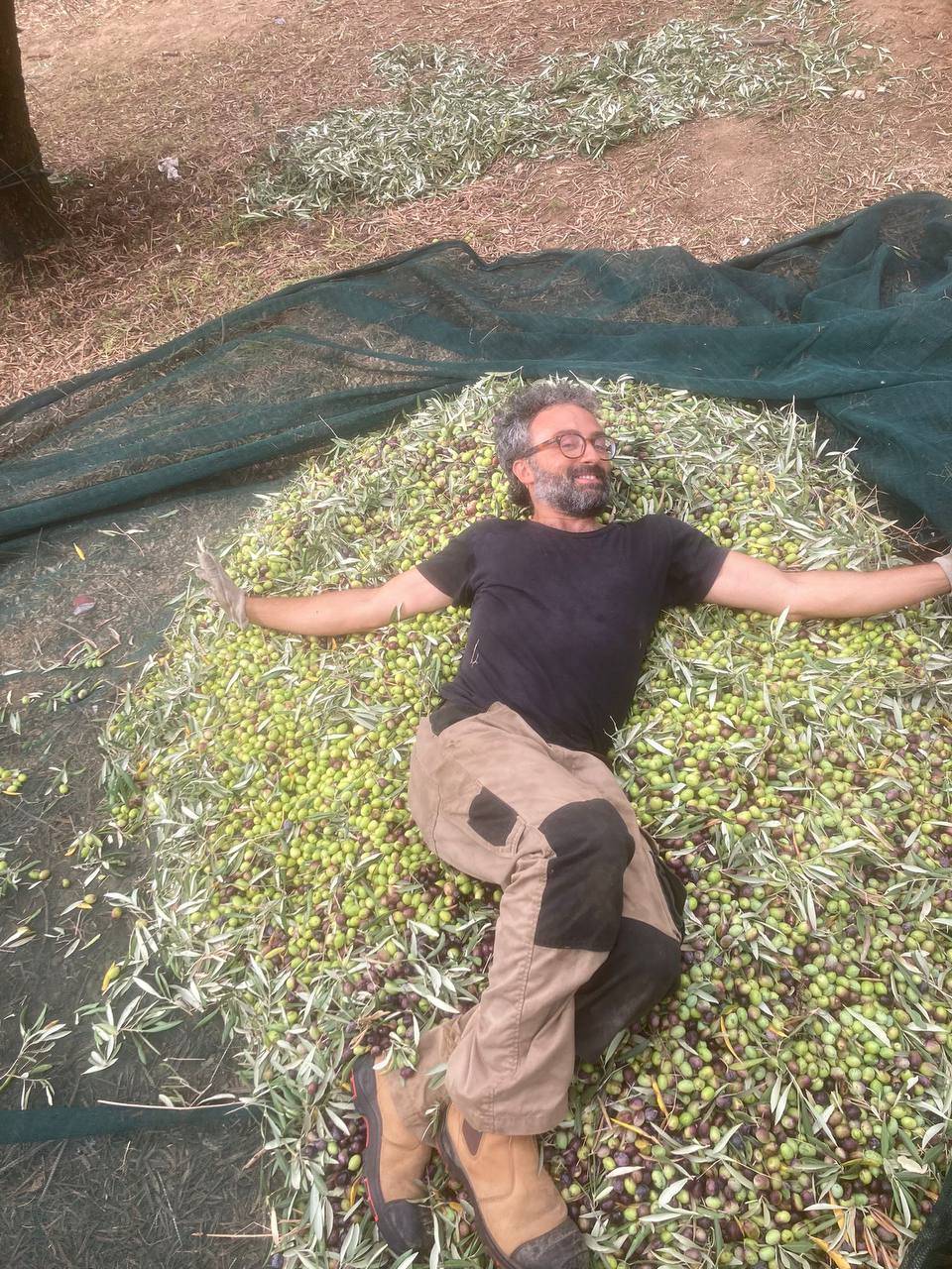 Giorgio sdraiato sul mucchio di olive