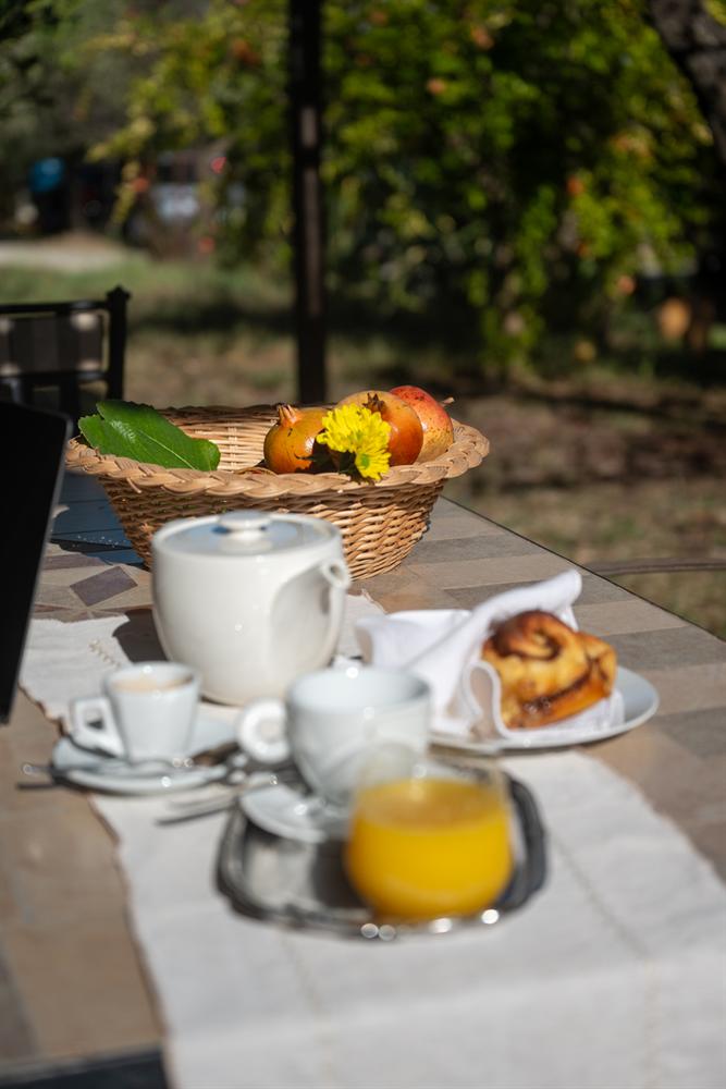 Tavola della colazione con caffè, succo d'arancia, dolce e un cesto di melograni