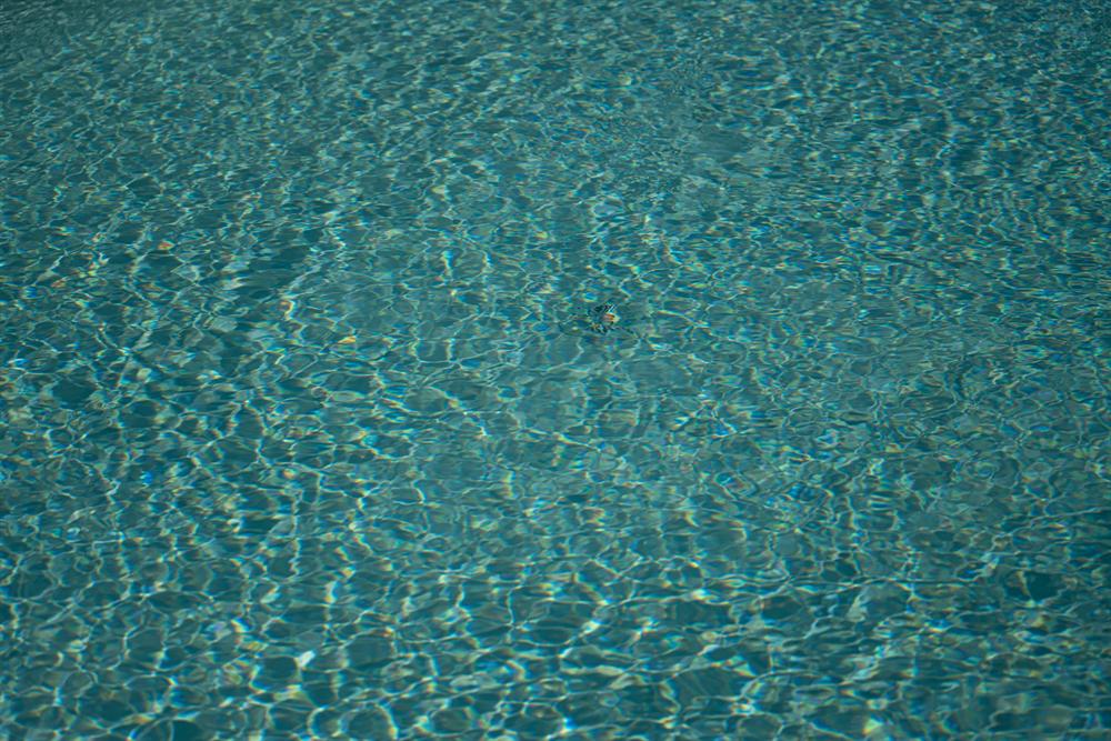L'acqua della piscina increspata, con riflessi di luce