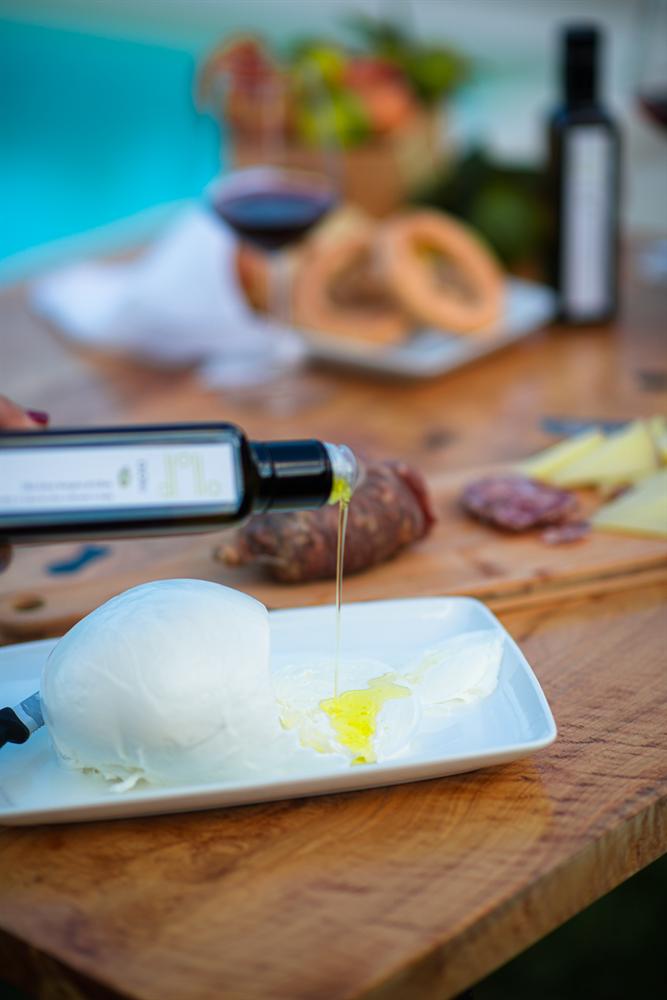 Olio extravergine versato su una mozzarella
