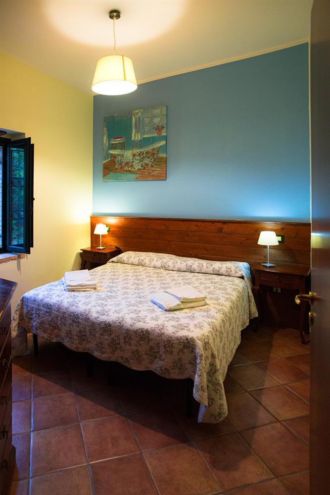 Camera matrimoniale con parete azzurra e un quadro con una vasca da bagno
